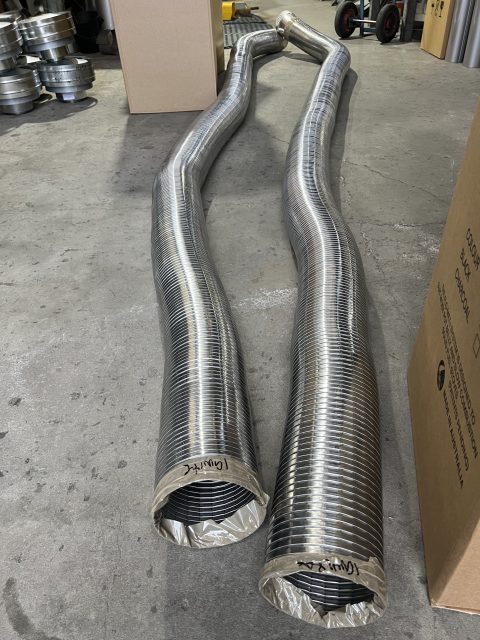 Two large metal ventilation ducts on warehouse floor.
