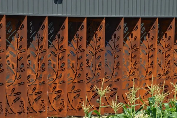Metal fence with floral cutouts and plants