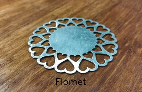 Heart-shaped metal coaster on wooden surface