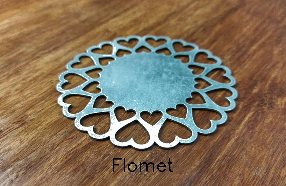 Heart-shaped metal coaster on wooden surface