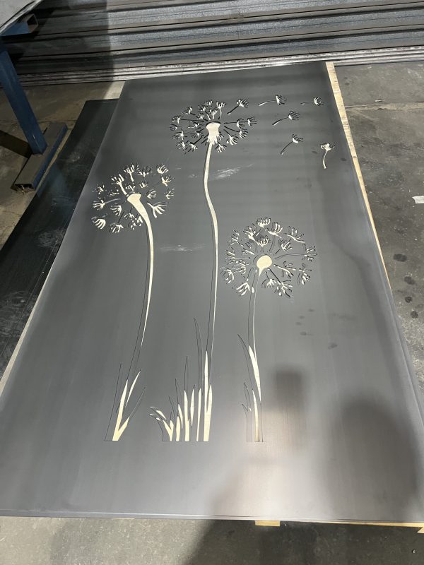 Metal panel with dandelion design cutouts.