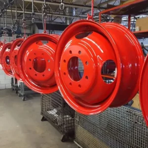 Red metal rims hanging in factory