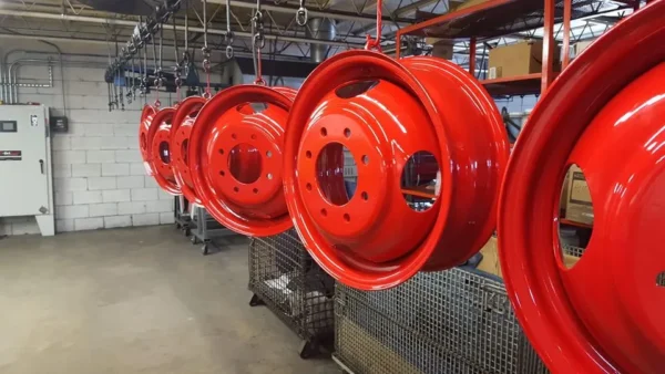 Red metal rims hanging in factory
