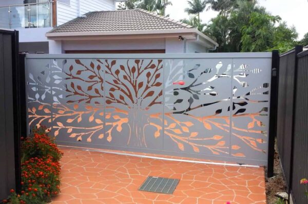 Metal gate with tree design near house entrance.